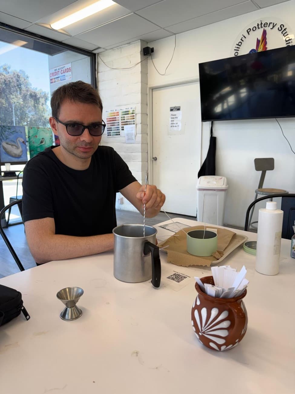 Stirring melted wax to pour a candle at the Campbell studio