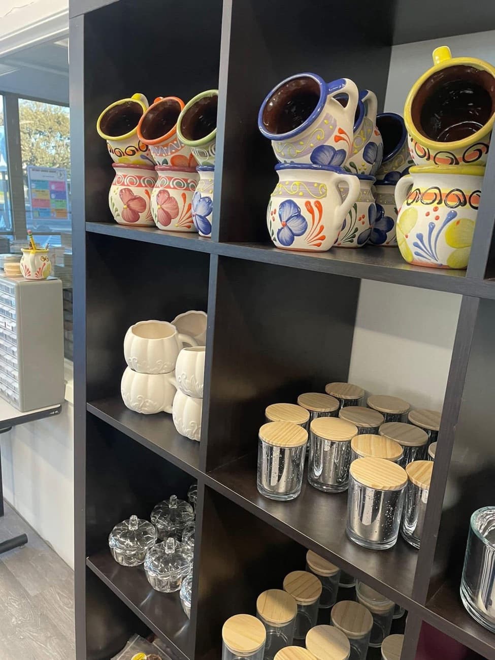 Empty candle vessels — mercury-glass and apothecary jars — on the shop shelf