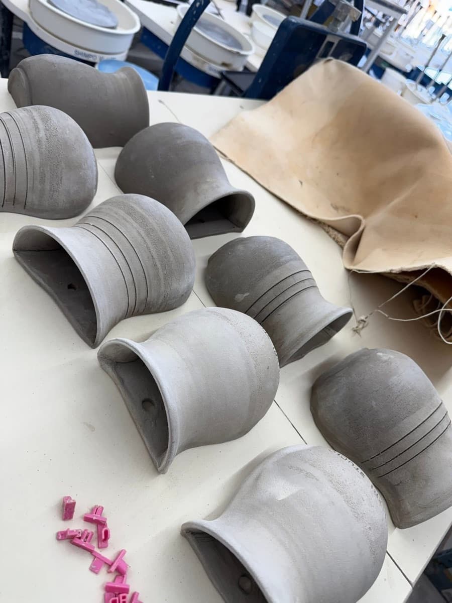 A row of small vessels straight off the wheel, throwing lines still crisp